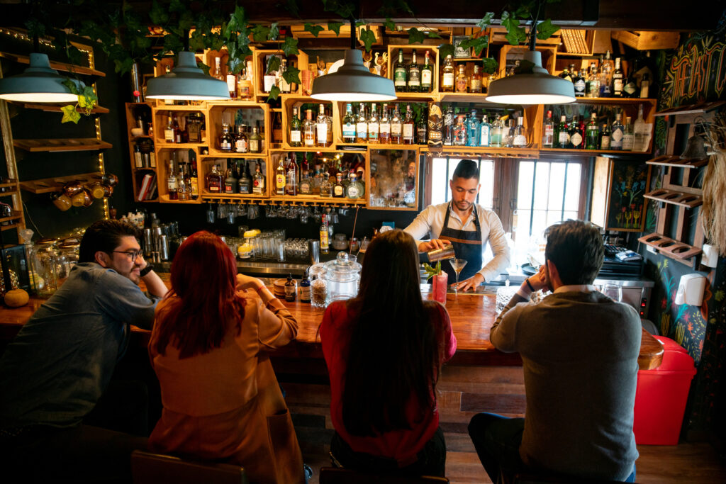 bartender at the bar making cocktails for people