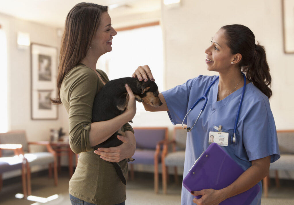 female veterinarian talking with dog owner