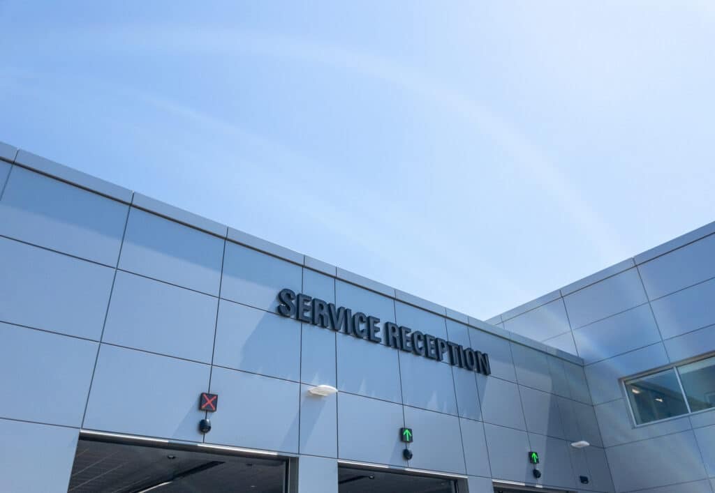 service reception sign on modern car dealership building